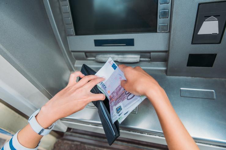 Persona preleva dei contanti dal un ATM bancomat - foto Depositphotos - PalermoLive.it