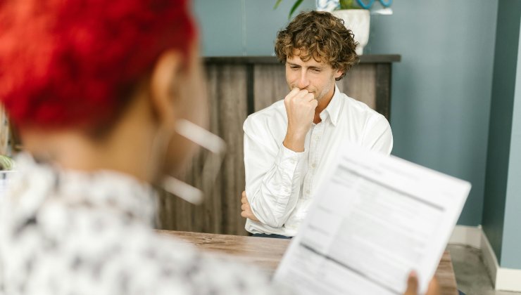 Giovane durante un colloquio di lavoro preoccupato per il suo cv